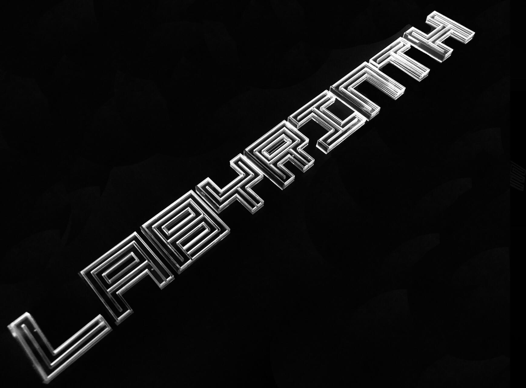 Text "LABYRINTH" in silver, stylized with geometric, maze-like lines on a black background.