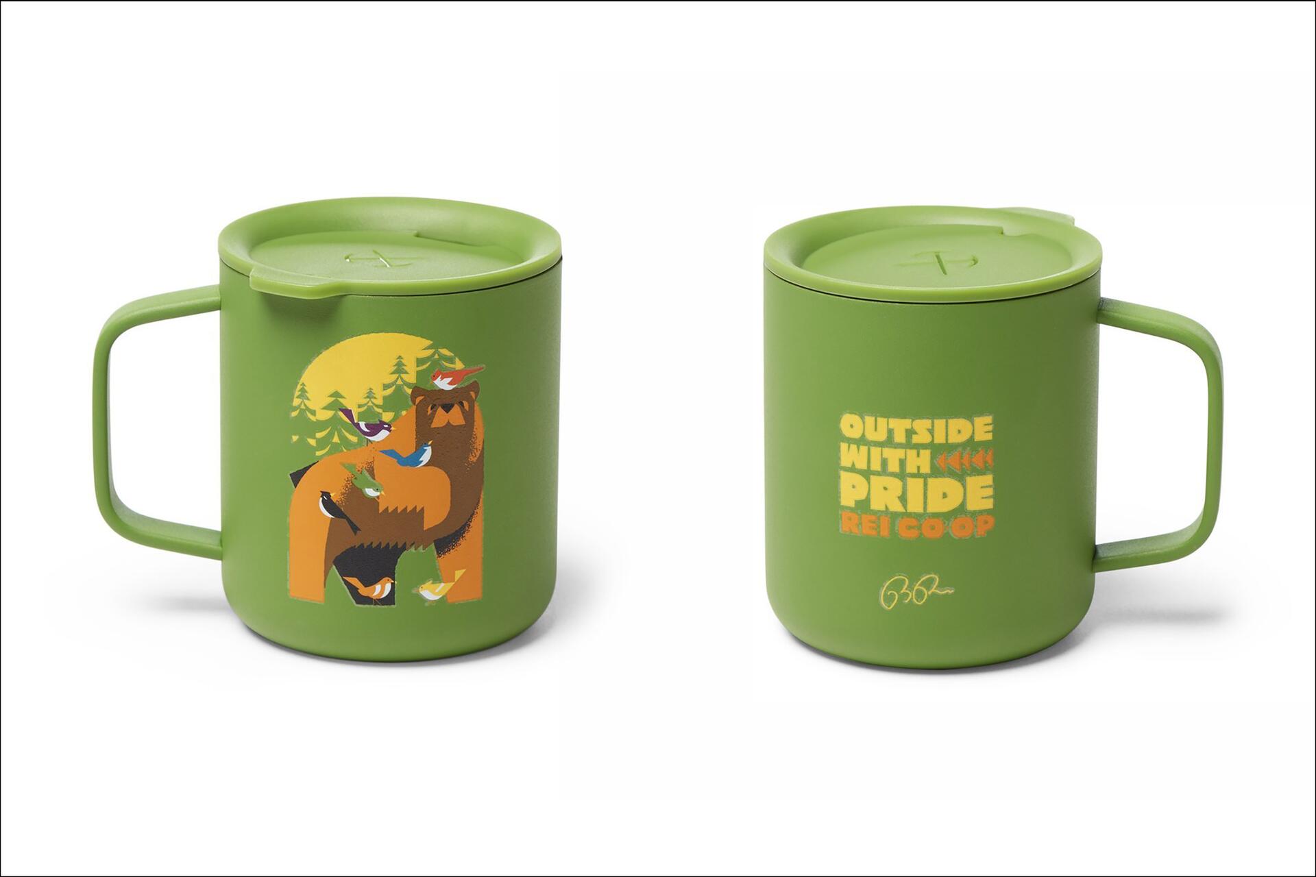 Two green mugs with lids. The left mug features an illustration of a bear surrounded by birds and trees. The right mug has the text "Outside with Pride REI Co-op" in yellow and orange. Both have green handles.