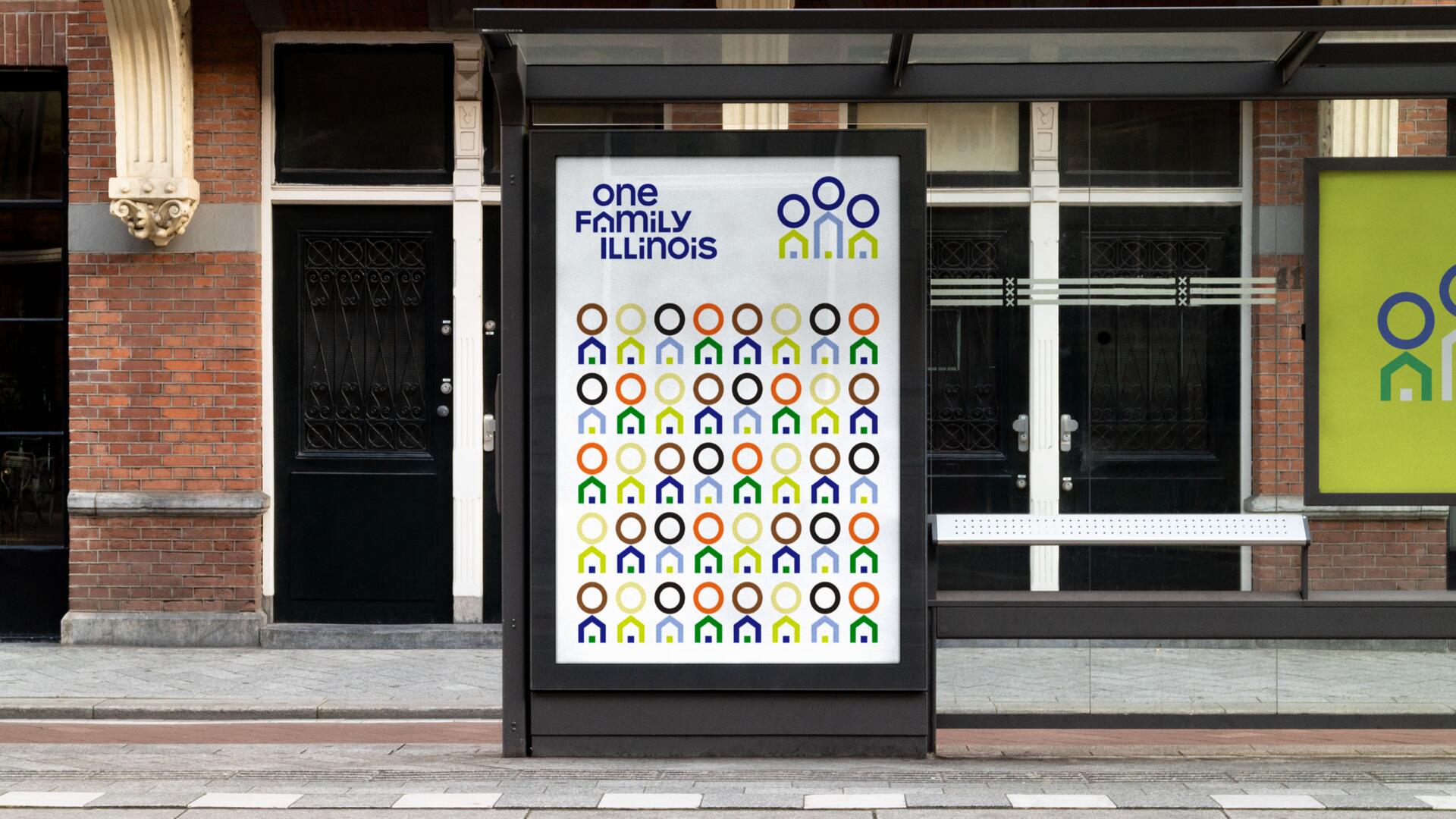 Bus stop advertisement with colorful circle and house icons on a white background, set against a brick building. Text and logos emphasize community in Illinois.