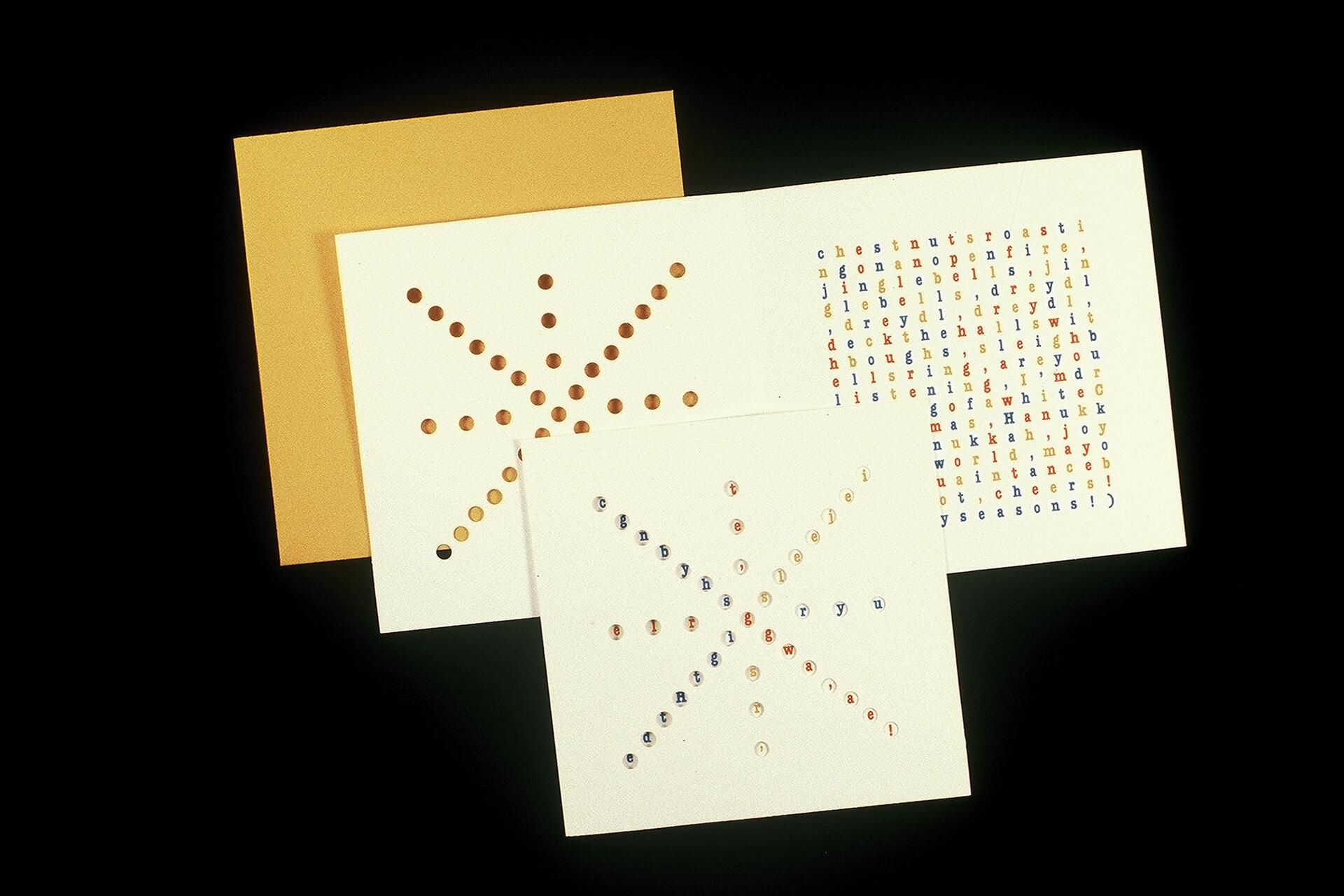 Three sheets of paper with punched holes and colorful letters. One paper has a star design with holes, and another contains a grid of letters in various colors. The background is black.