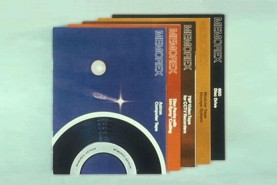 Stack of colorful Memorex cassette tapes featuring different designs and colors, with the front one in blue displaying a space-themed graphic.