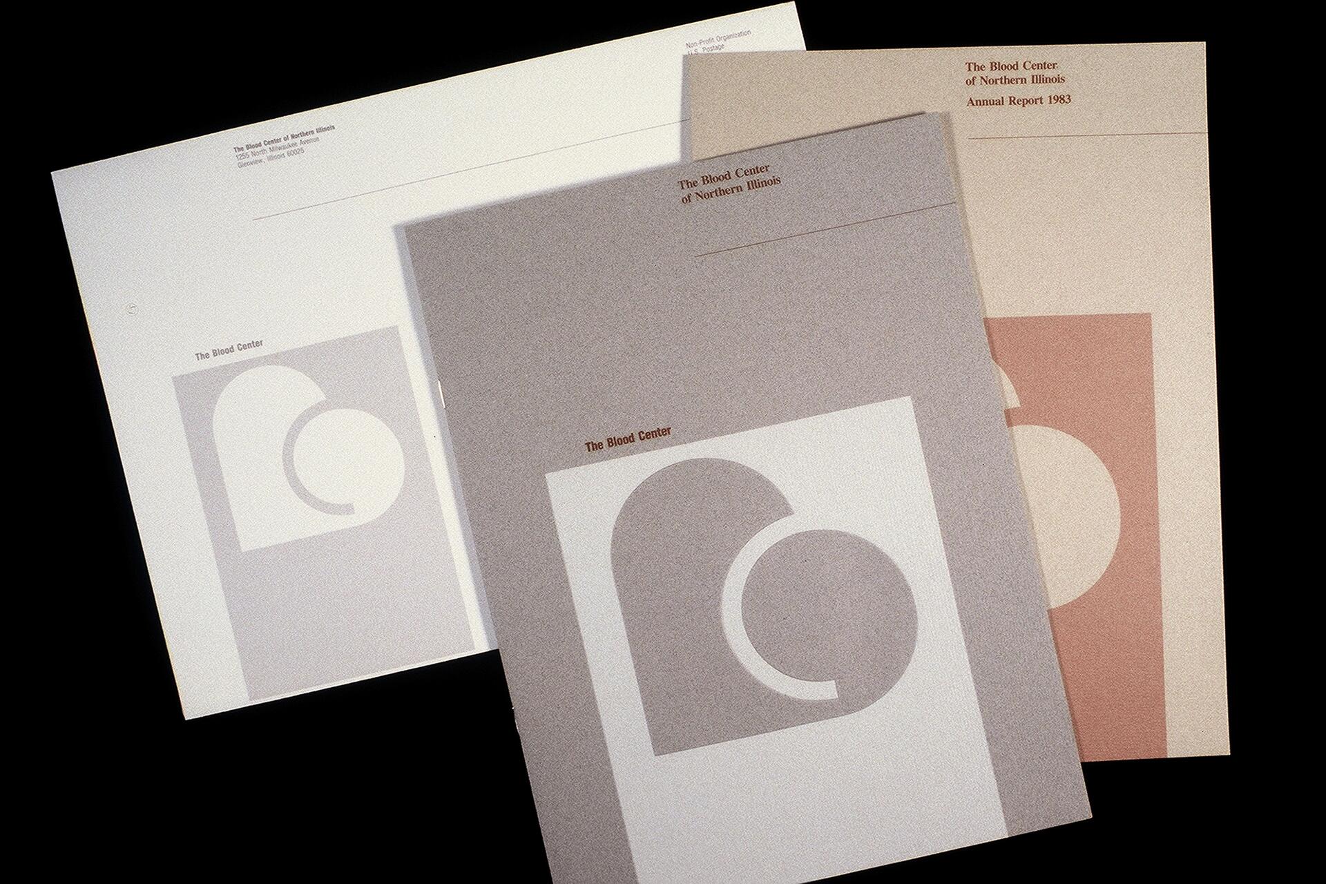 Three annual reports overlapping, each featuring a stylized heart logo. The reports are from The Blood Center of Northern Illinois, in muted tones of gray, beige, and a reddish hue.