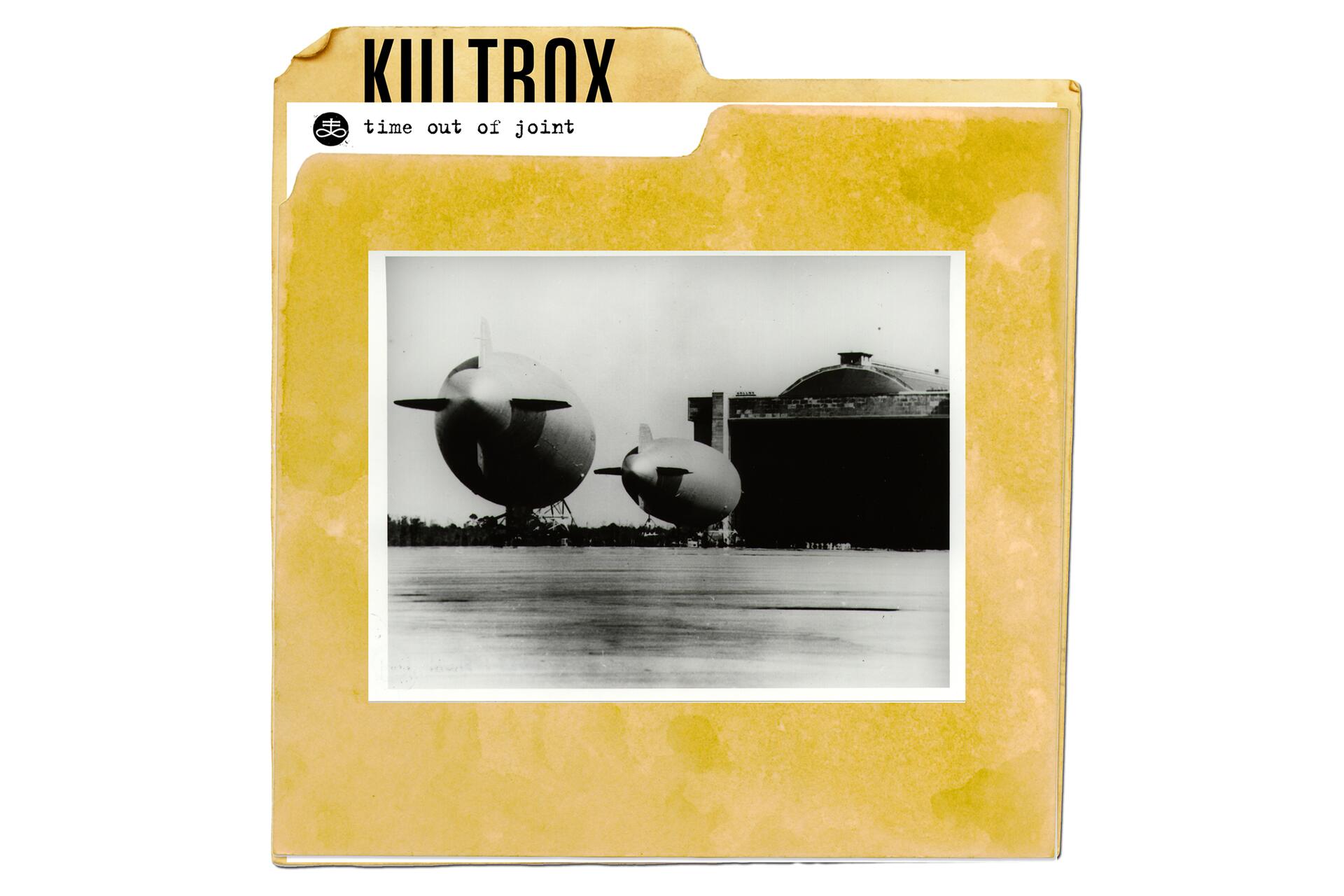 Yellow file folder with vintage black-and-white photograph of two airships in front of a hangar.