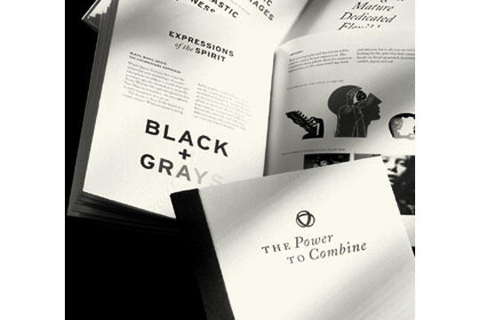 Open monochrome books displaying pages with text and graphics, one prominently featuring "BLACK + GRAYS" and another with "THE Power to Combine" on the cover.