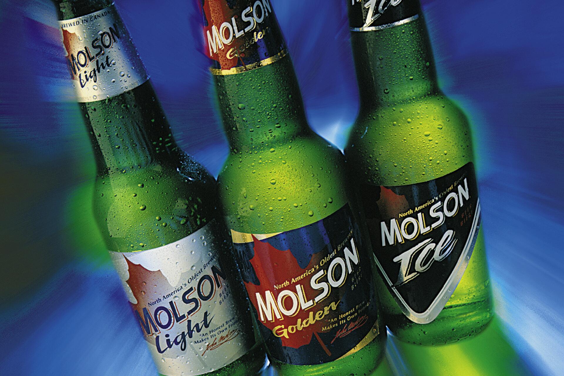Three green Molson beer bottles—Light, Golden, and Ice—angled against a dynamic blue and green background. Water droplets cover the bottles, suggesting coldness.