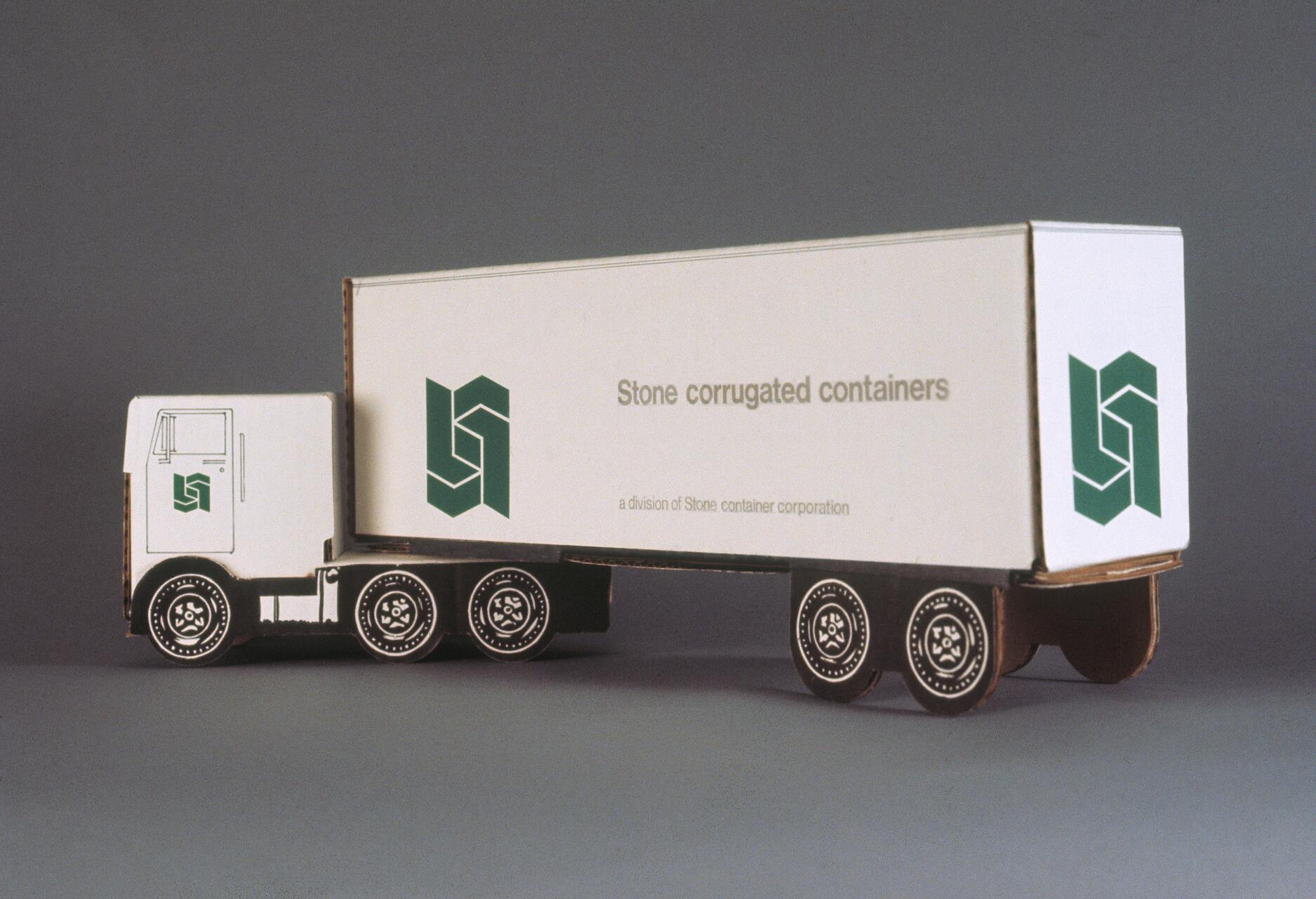 Cardboard model of a truck with "Stone corrugated containers" text and green logo on the side, shown against a plain background.