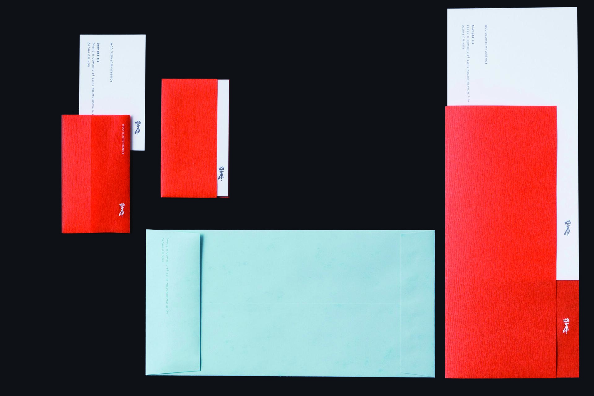Assorted red and turquoise stationery set on a dark background.