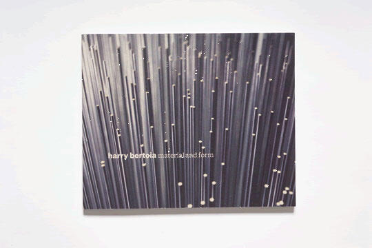Book cover with thin, vertical, white lines on a dark background, resembling light streaks. Text reads "harry bertoia material and form" in lowercase letters.