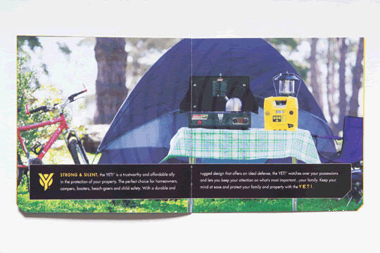 A graphic showing a camping scene with a blue tent, a picnic table covered with a green plaid cloth, a stove, lantern, and yellow equipment. A red bicycle leans against a tree in the background under a sunny sky.