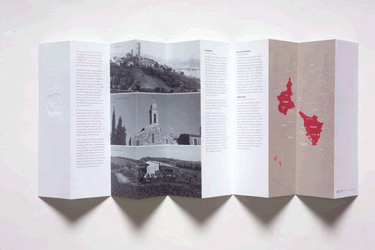 Folded brochure with black-and-white photos of landscapes and buildings, text columns, and a map with highlighted regions in red.
