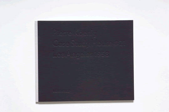 A dark book cover with embossed text difficult to read.