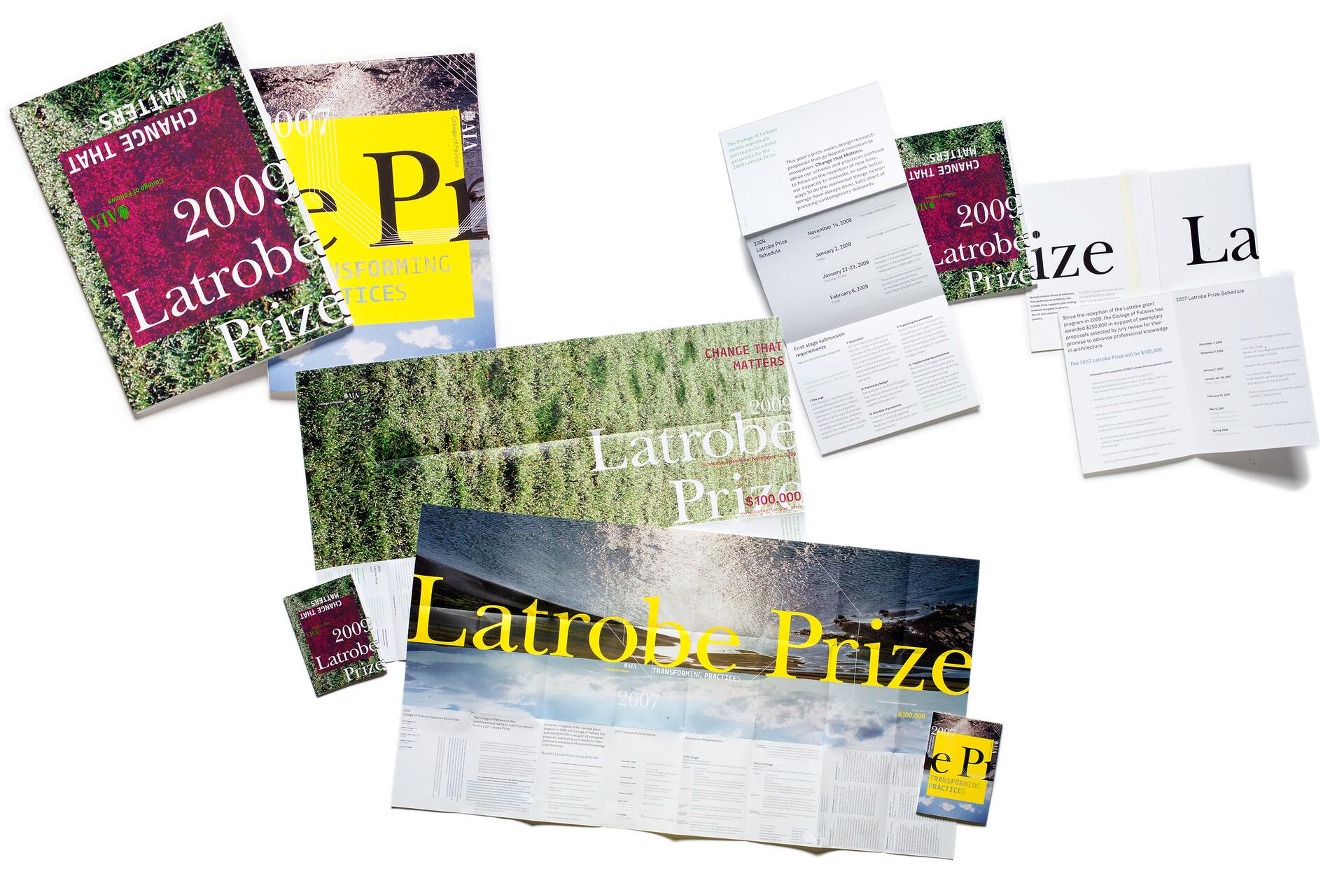 Various print materials and brochures featuring vibrant designs and text related to the "Latrobe Prize," displayed in an overlapping arrangement.