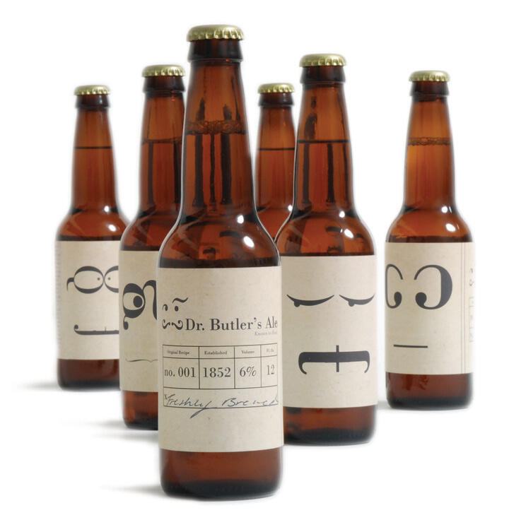 Five brown beer bottles with labels featuring stylized faces. The labels display various facial expressions using simple lines and dots. The main bottle reads "Dr. Butler's Ale."