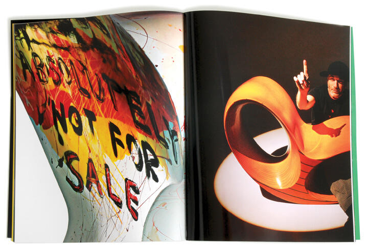 Open book with a colorful abstract design and text on the left page, and a man sitting on a modern, orange looped chair on the right page.