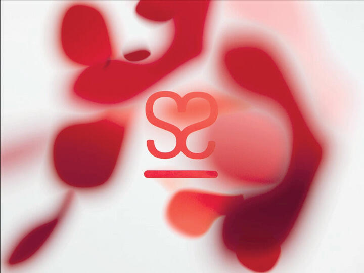 Abstract graphic with red and pink blurred shapes on a white background, featuring a stylized heart symbol and a horizontal line in the center.