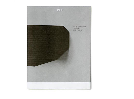 Magazine cover with a minimalist design featuring a large dark geometric shape on a pale gray background. The word "VOL" is centered at the top, and there is some additional text on the right side.