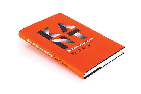 Red book titled "Kant & Phenomenology" by Tom Rockmore, lying on a white surface. The title is prominently displayed in bold black and white letters.