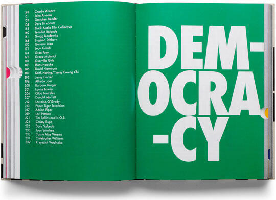 Open book with a green background. Left page lists names in white text; right page shows large, bold white letters reading "DEMOCRACY" split into three lines.