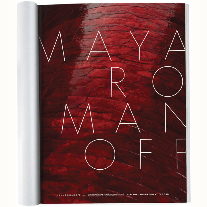 Open magazine with a close-up of a red textured surface, featuring large white letters spelling "MAYA ROMANOFF."