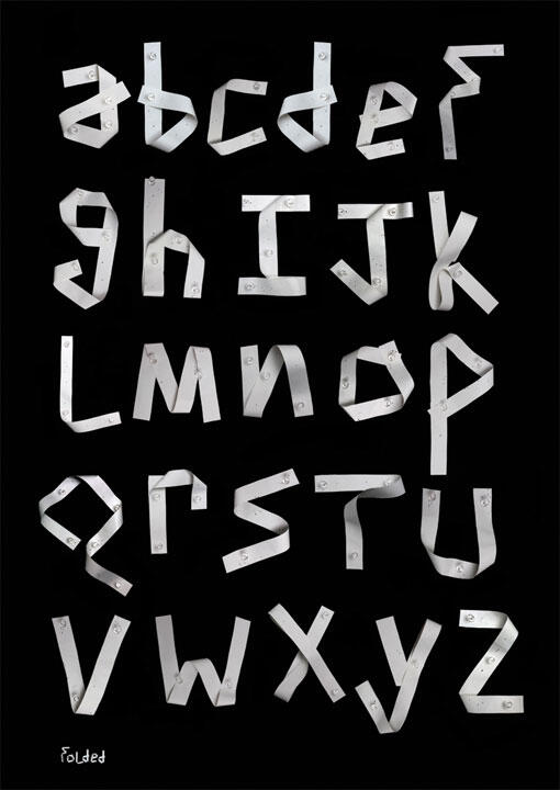 Alphabet letters crafted from folded white measuring tape on a black background.