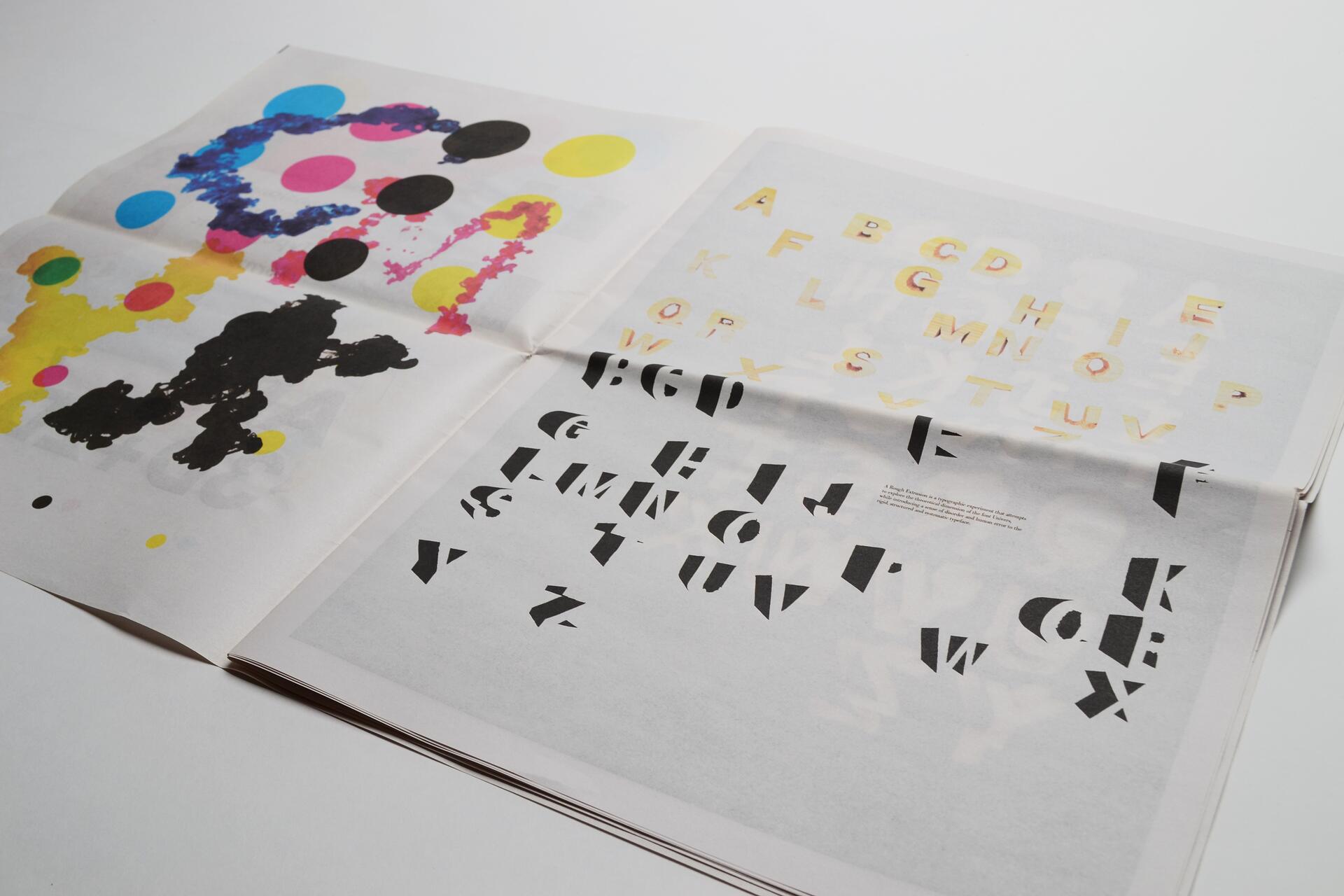 Open magazine with colorful abstract shapes and alphabets on the left page. Right page features stylized letters in yellow and black.