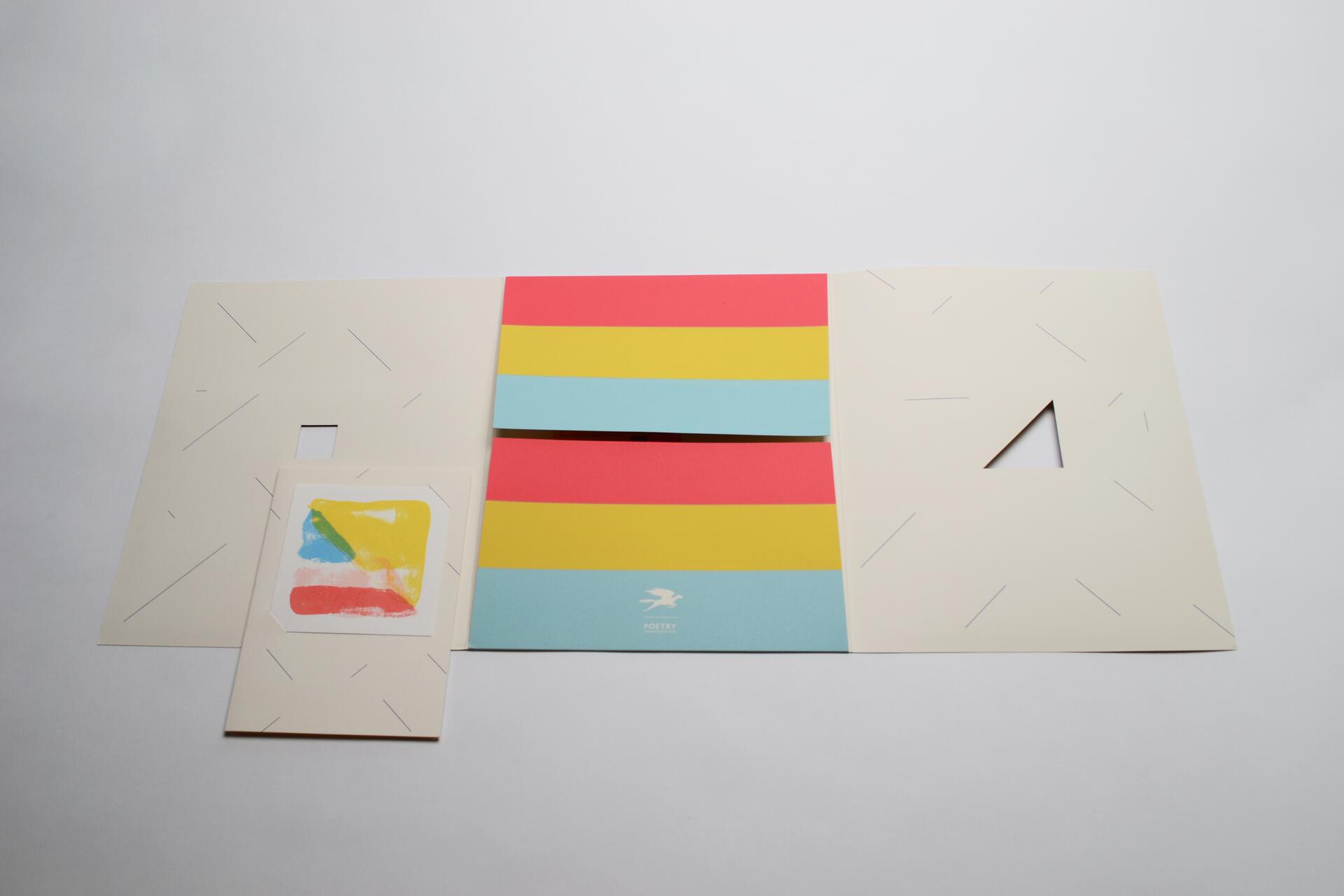 Colorful folded paper with horizontal stripes in red, yellow, and blue, set on a white background. Abstract art in similar colors is on the left. The paper has cut-out sections and thin lines.