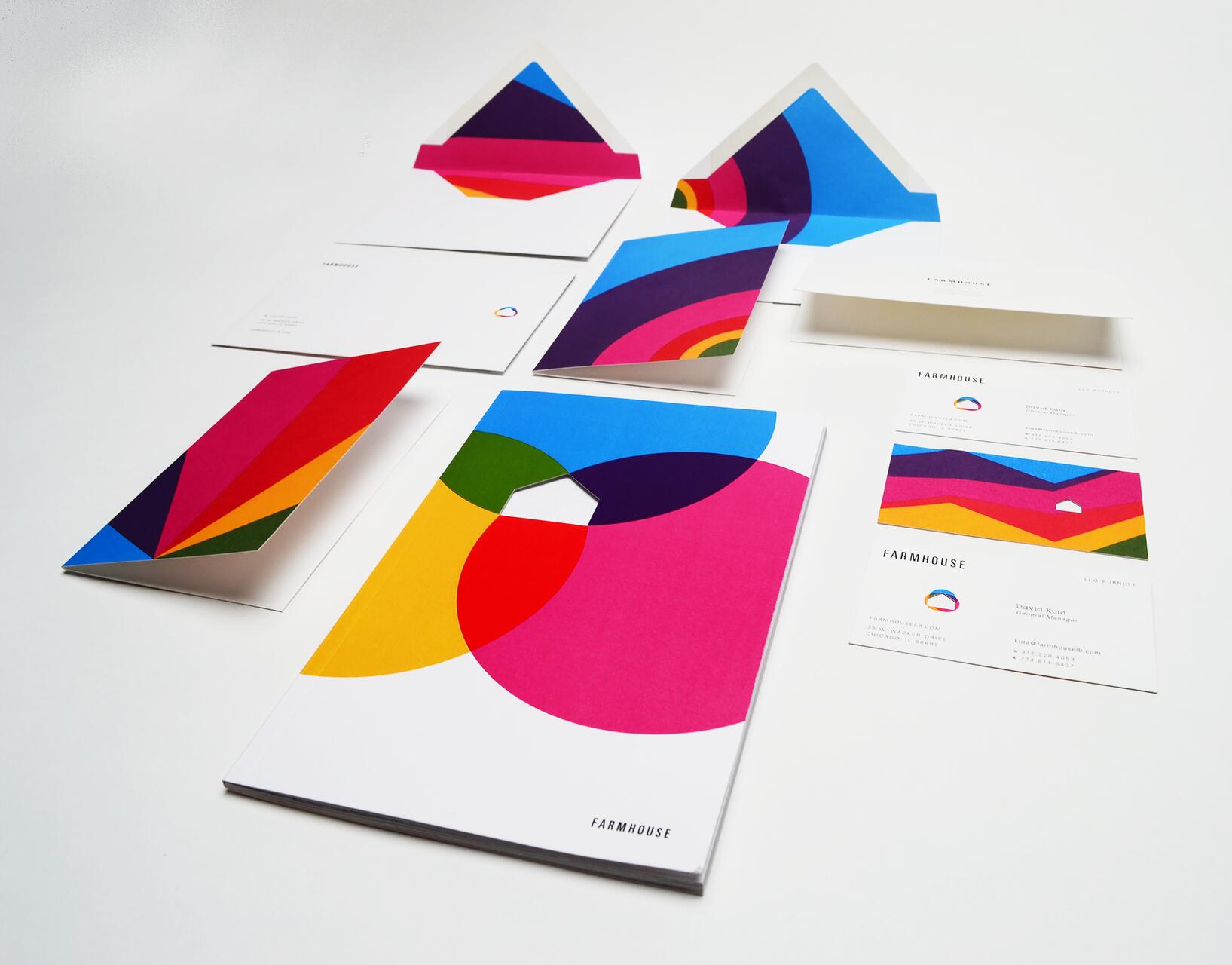 Colorful stationery set with geometric designs, including envelopes, business cards, and a letterhead. Dominant colors are pink, blue, yellow, and green. Each item features a modern and vibrant style.