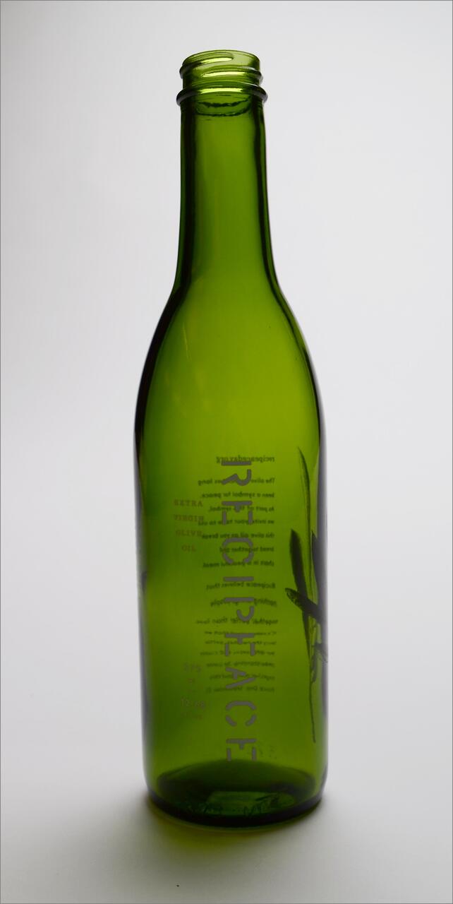 Empty green glass wine bottle with embossed text.