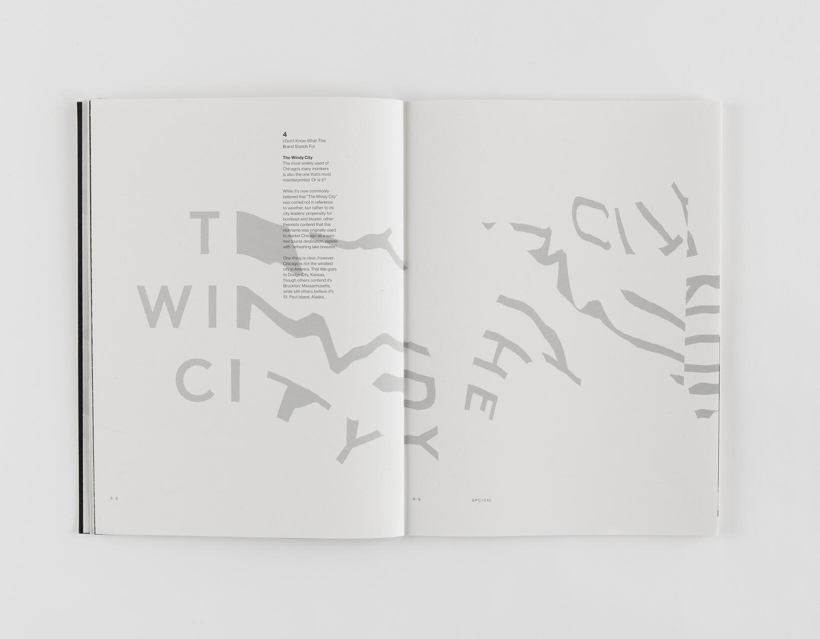 Open book with text and large, fragmented letters spelling "THE WINDY CITY" across two pages in light gray.