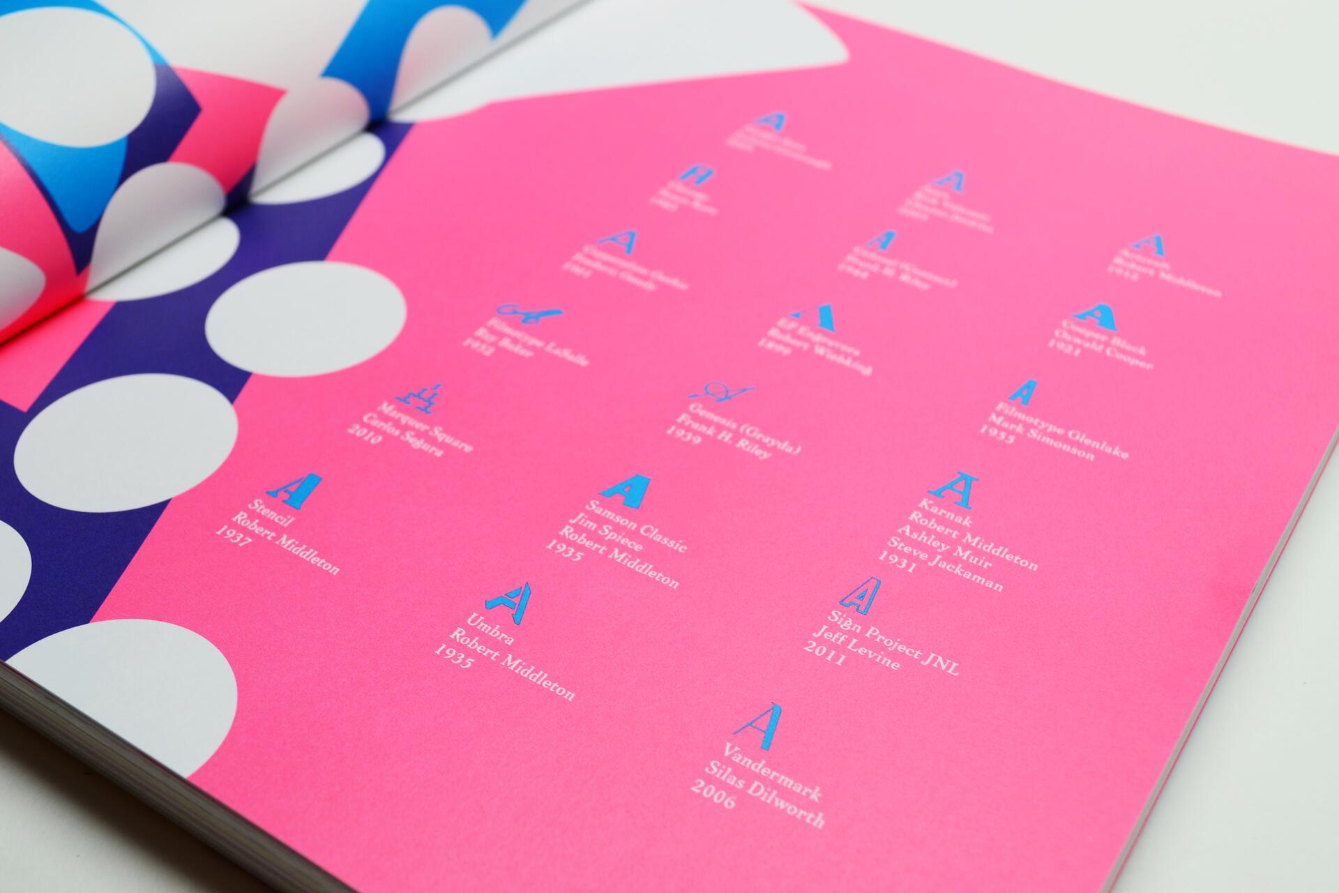 Open book with a bright pink page featuring blue and white typography against a colorful overlay of purple and white circles.