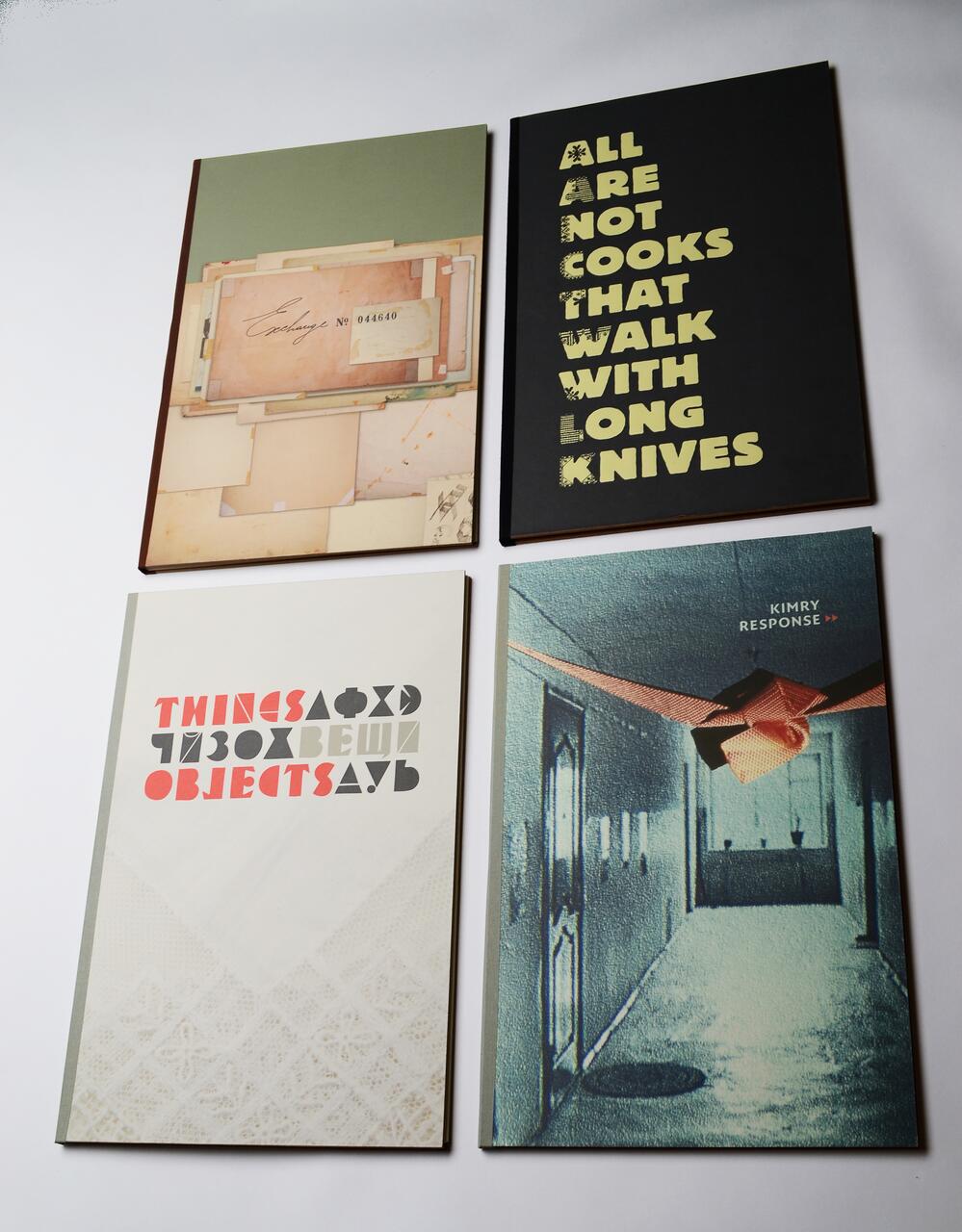 Four book covers with varied designs. Top left has layered papers, top right features bold text on a black background, bottom left shows abstract text over lace, and bottom right has a hallway scene in blue-green tones with "Kimry Response" text.