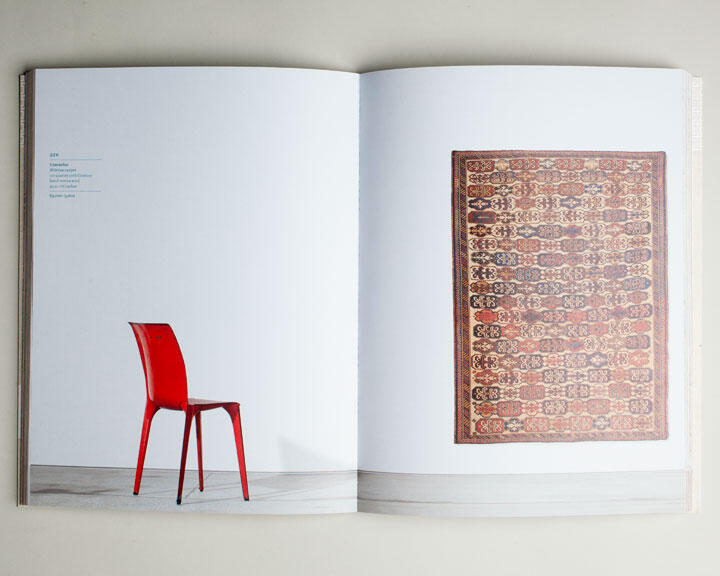 Open magazine displaying a red chair on the left page, and a colorful patterned rug on the right page.
