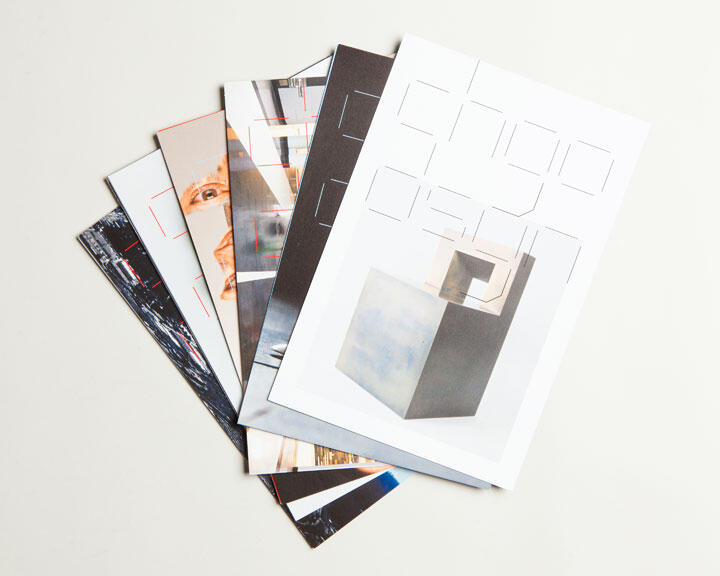 A stack of art magazines fanned out, each with different abstract and architectural designs on the covers, placed on a light background.