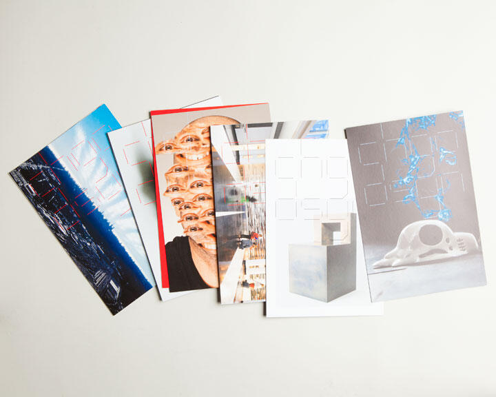 Colorful postcards fanned out on a white surface, featuring various abstract and surreal designs.