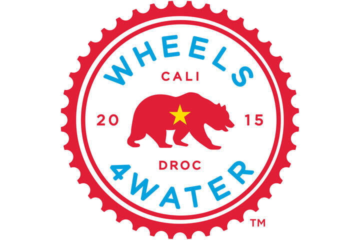 Logo featuring a red gear outline with a red bear and yellow star. Text encircling reads "Wheels 4 Water" in blue, with "Cali 2015 DROC" in red.