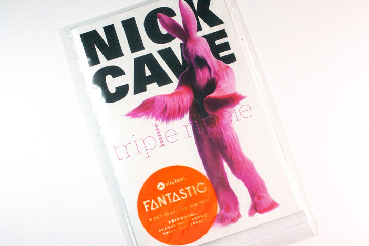 Poster featuring a pink, furry, humanoid figure with rabbit ears. Large black text at the top reads "Nick Cave," and below, "triple ripple" in pink. A red circle at the bottom contains "FANTASTIC" with event details.