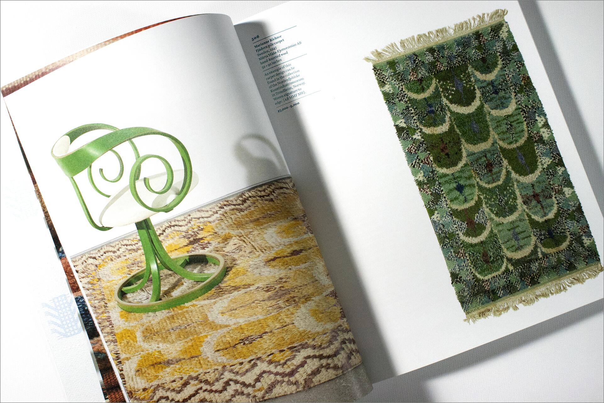 Open book showing a green sculptural lamp on a patterned rug on the left page and a green, intricately patterned tapestry on the right page.