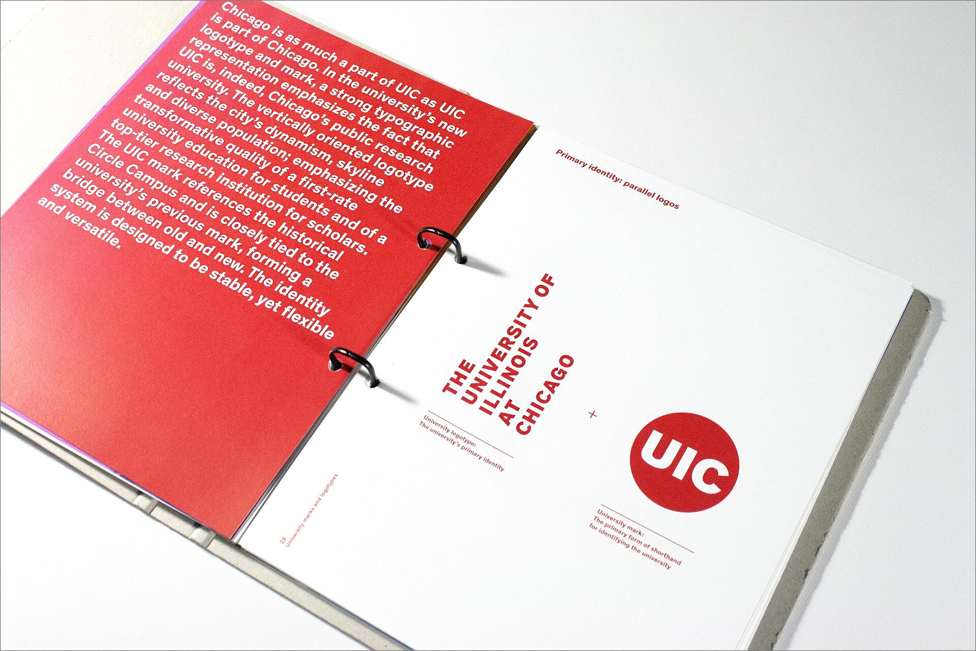 Open design booklet with red and white pages, featuring text about the University of Illinois at Chicago's identity and logo. Red circle with "UIC" on the right page, bold red text and black binder rings are visible.
