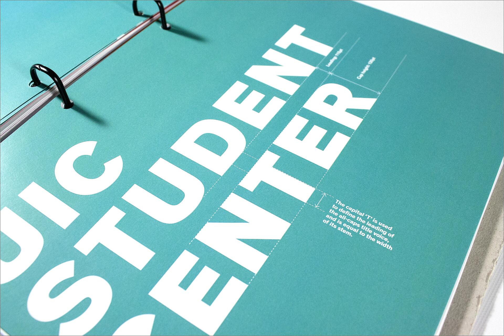 Text on a turquoise page spelling "STUDENT CENTER" in large white letters, bound by black rings.