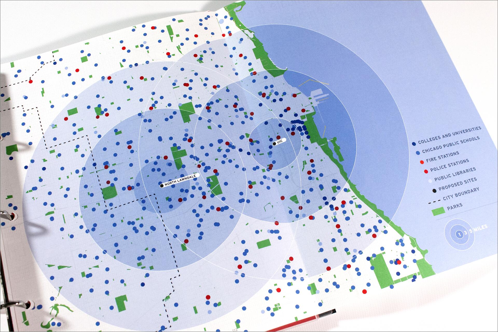 Map of Chicago with colored dots and symbols representing schools, fire stations, police stations, public libraries, and proposed sites. Areas are marked with circles indicating distance, and parks are highlighted in green.