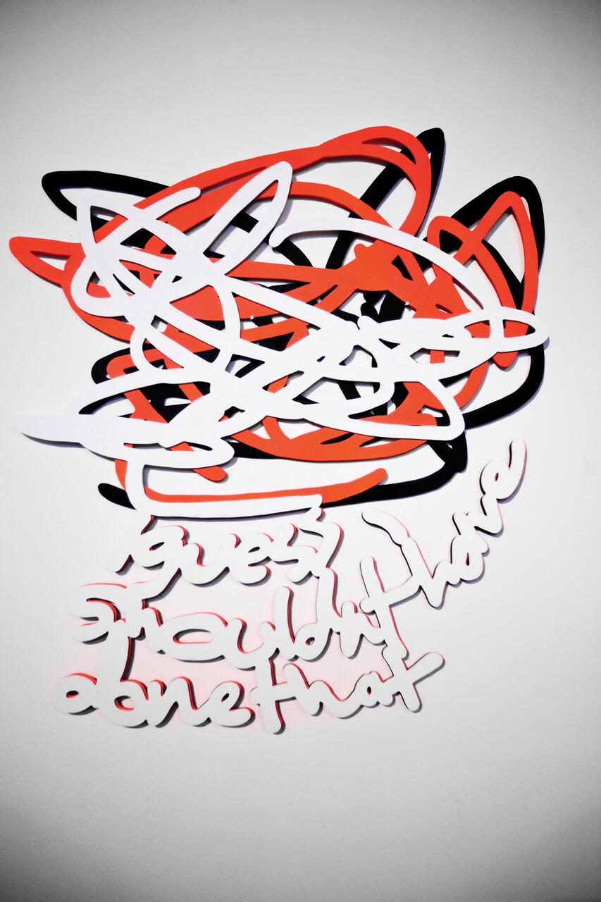Colorful abstract wall art with black, red, and white swirling lines, creating a chaotic pattern. Below, text reads, "guess I shouldn’t have done that," in stylized lettering.