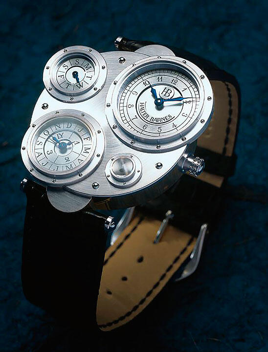 Luxurious watch with multiple dials set against a deep blue background. The watch features a large dial with silver and blue accents, flanked by two smaller dials, all within a steel casing and a black leather strap.