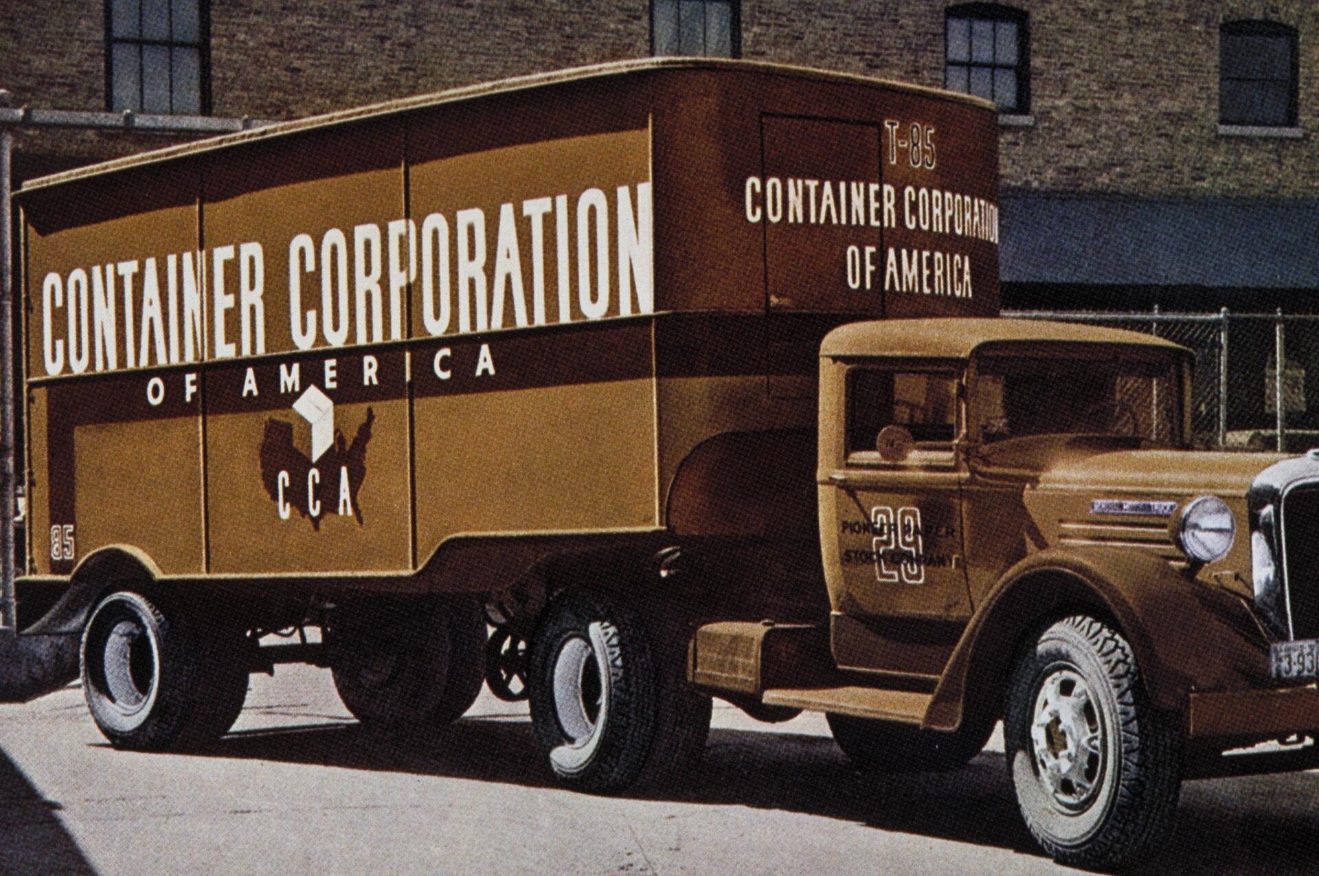 Brown vintage delivery truck with "Container Corporation of America" branding on the side, parked on a city street with a brick building in the background.
