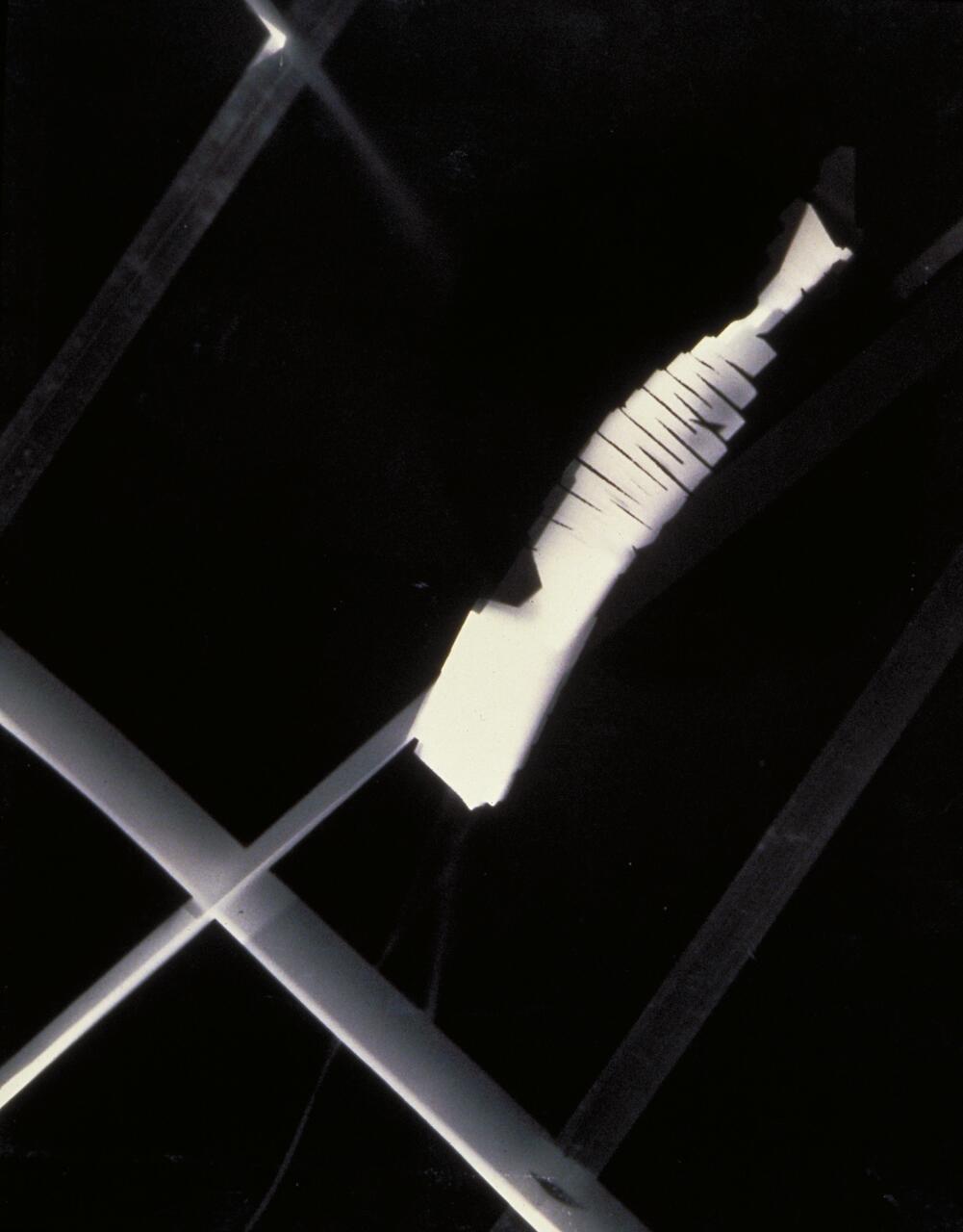 Abstract composition with intersecting light and dark geometric shapes, featuring a segmented, diagonal white beam against a black background.