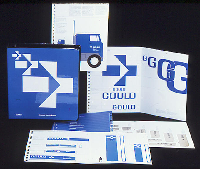 Collection of Gould corporate identity materials, featuring blue and white designs, including a binder, brochures, and folders displayed on a black background.