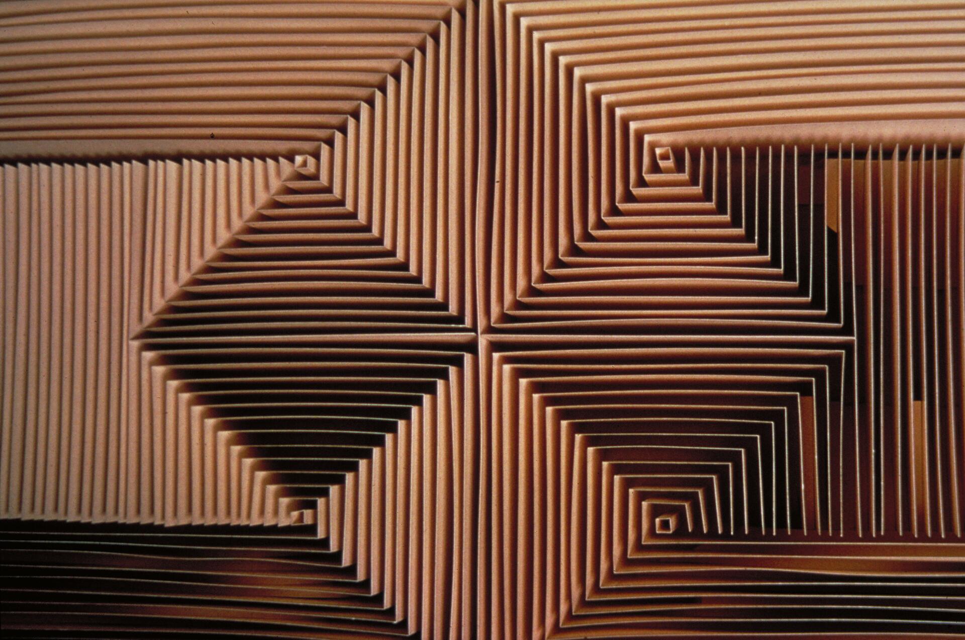 Geometric pattern featuring layered, concentric squares in a spiral formation, creating a textured, three-dimensional optical illusion in shades of brown.