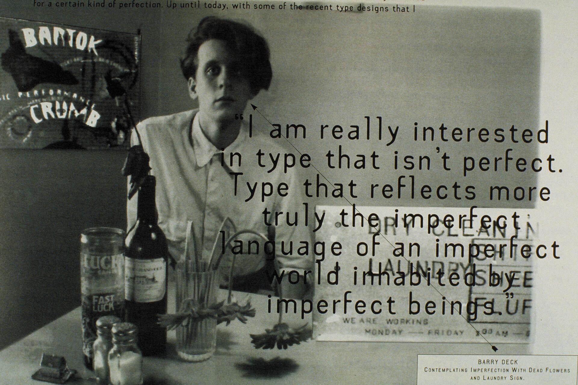 Black and white photograph of a person sitting at a table with flowers, a bottle, and a glass. Text overlay discusses interest in imperfect typography. A blurry sign and a poster in the background add a contemplative atmosphere.