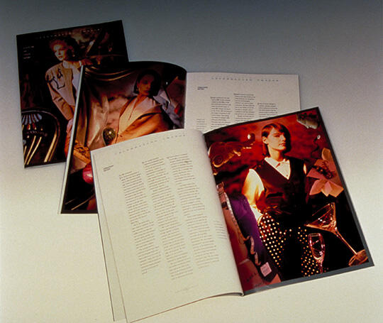 Open magazines with colorful fashion-focused photographs scattered on a surface, featuring models in stylish outfits alongside pages of text.