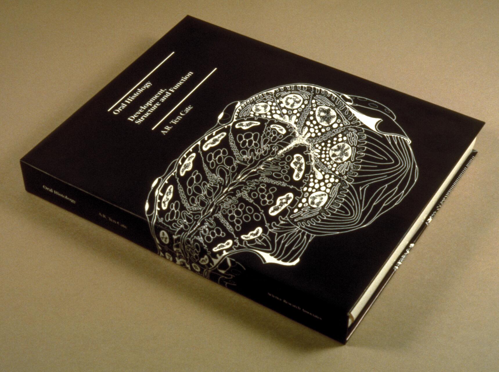 Closed book with a black cover displaying intricate white biological illustrations.