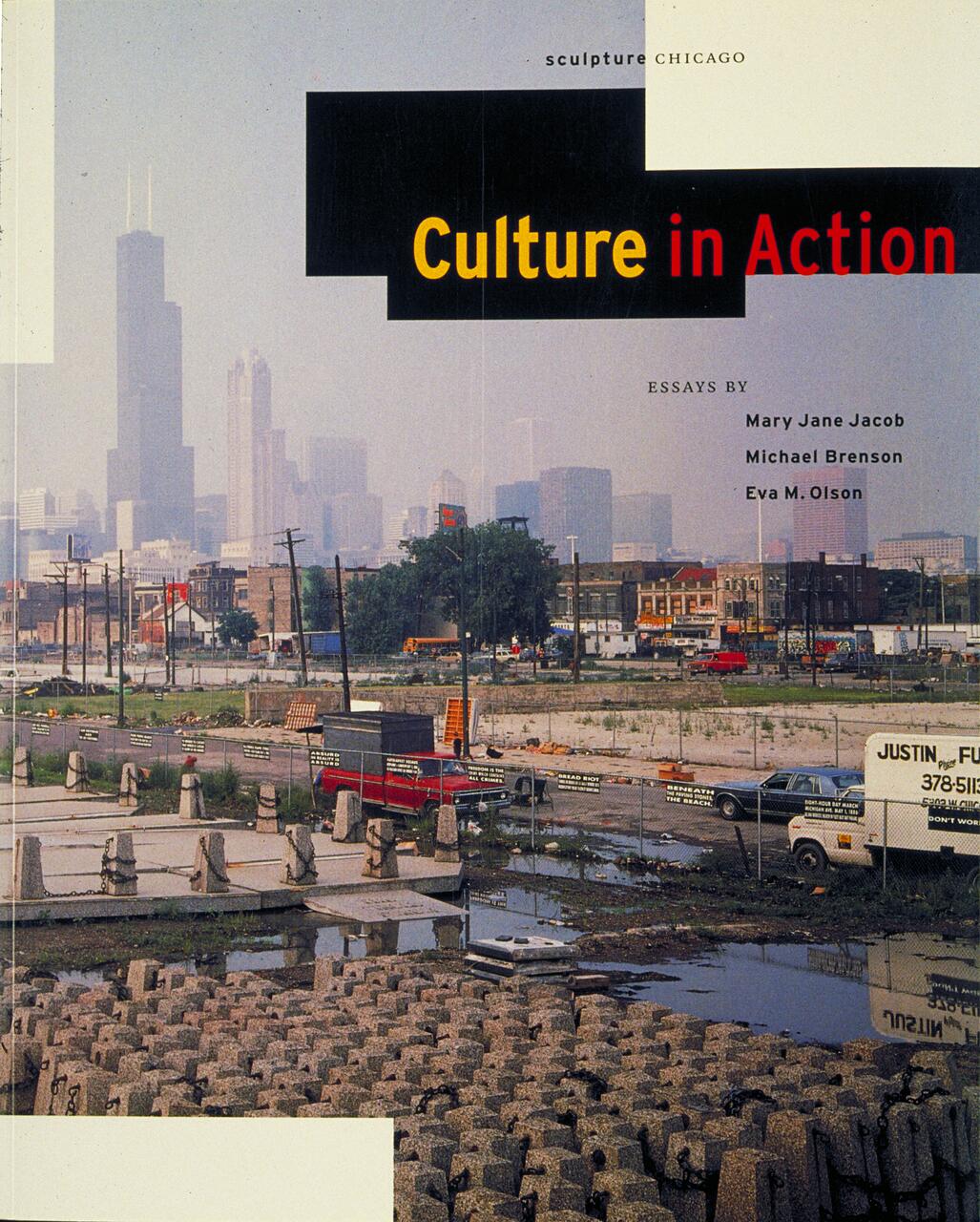 Urban landscape with scattered construction materials and vehicles, set against a hazy city skyline dominated by skyscrapers, including the Willis Tower.